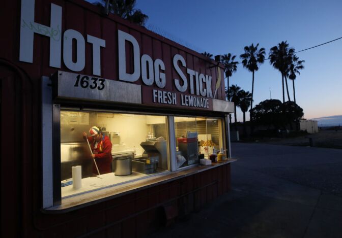 SANTA MONICA, CALIFORNIA  - MARCH 17: A worker cleans at a carryout hot dog stand on Santa Monica beach on March 17, 2020 in Santa Monica, California. Carryout restaurants are currently allowed to remain open in Los Angeles County. COVID-19 has claimed 13 lives in California so far with at least 470 people in the state testing positive for the coronavirus. Many more carry the coronavirus but have not been tested, according to officials. (Photo by Mario Tama/Getty Images)