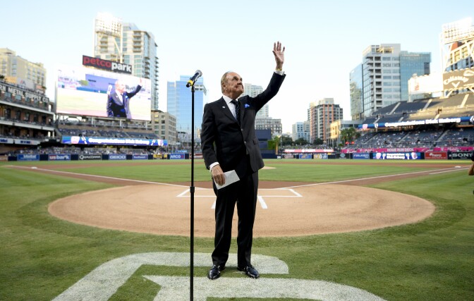 SAN DIEGO, CALIFORNIA - SEPTEMBER 29:  San Diego Padres announcer Dick Enberg waves to the crowd during a ceremony held before a baseball game between the San Diego Padres and the Los Angeles Dodgers at PETCO Park on September 29, 2016 in San Diego, California. The Padres held the pre-game ceremony to honor Enberg's last home game as the team's primary play-by-play man for television broadcasts.  (Photo by Denis Poroy/Getty Images)
