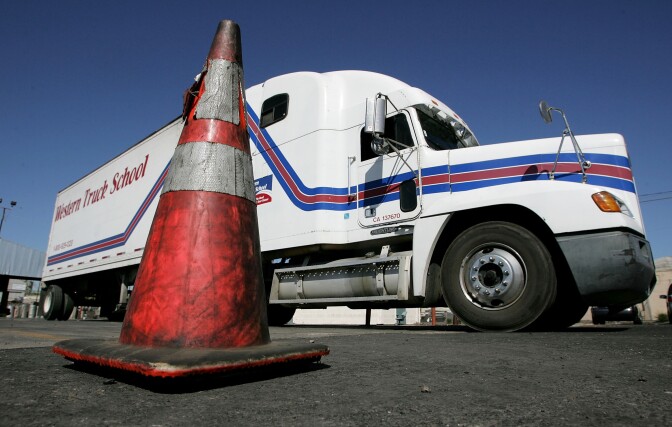 File: A semi-truck maneuvers around a traffic cone during training at the Western Trucking School Aug. 3, 2005 in Turlock, California.