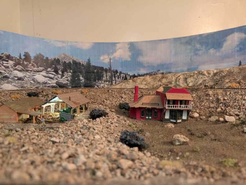 Miniature houses set in a mountainous landscape.
