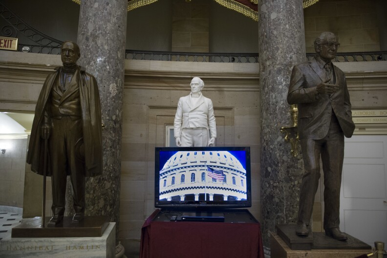 A video monitor sits in front of the statues of, from left, former Vice President Hannibal Hannibal of Maine, former Representative and Senator Daniel Webster and former Arizona Sen. Barry Goldwater in Statuary Hall on Capitol Hill in Washington, Tuesday, Jan. 3, 2017 as the 115th Congress begins. (AP Photo/Cliff Owen)