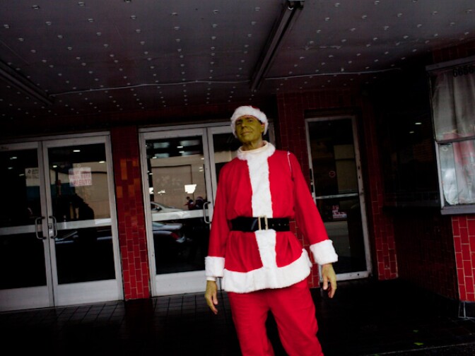 A Santa Grinch overlooks the crowd of fun loving Santas.