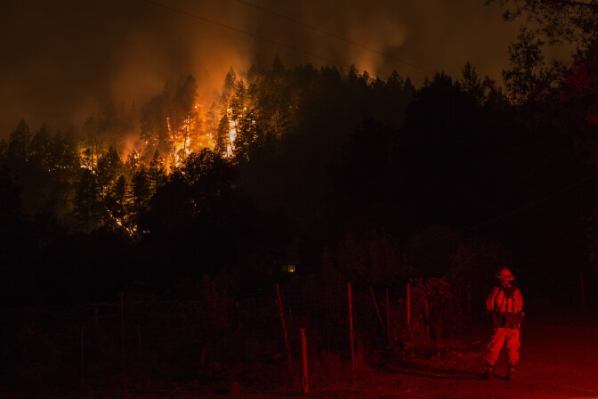 Wildfire creeps burns on the south side of Dry Creek Canyon at the Partrick Fire west of Napa, California on October 12, 2017.