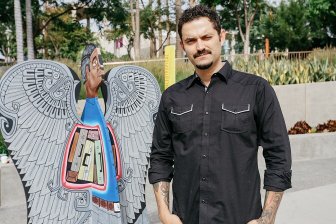 Artist Alvaro Marquez stands next to his angel, "Emotional Baggage" at the "We are Los Angeles" exhibit at Grand Park.