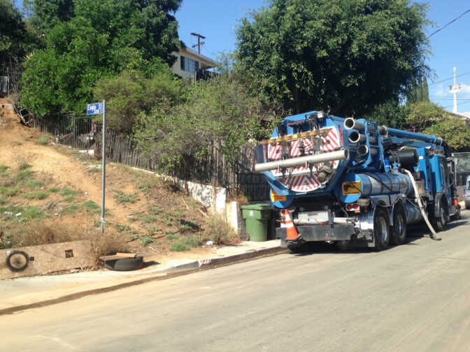 A tire and other debris sits on the sidewalk near a Los Angeles city sanitation truck on Bernal Avenue in Boyle Heights.