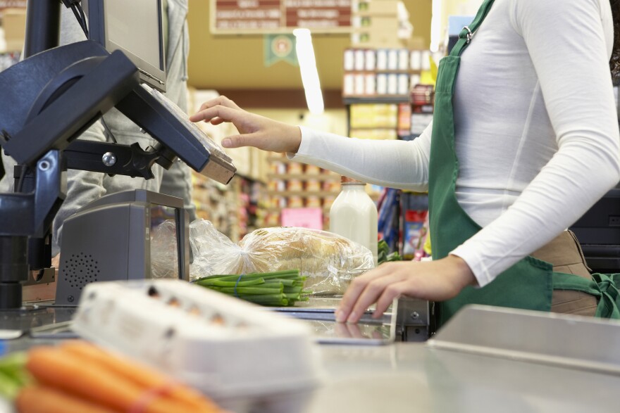 Close up photo of a cashier ringing up items at a supermarket check-out line