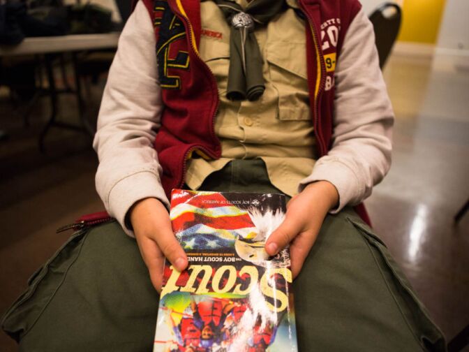 A Boy Scout holds a copy of the Scout Handbook during a meeting at Temple Beth Hillel in North Hollywood.