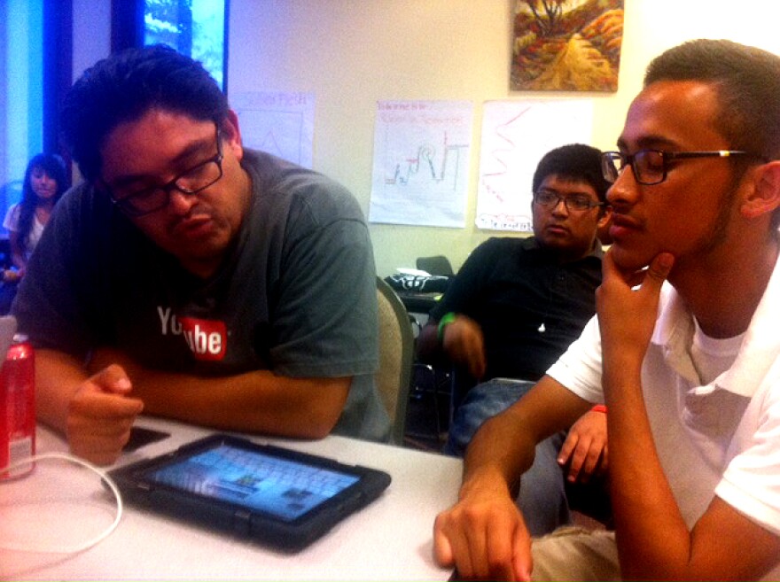 Developer Oscar Menjivar sits with student Jesus Vargas, checking out the Pearson education software loaded onto every L.A. Unified iPad.
