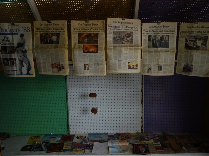 The inside of an improvised structure with old L.A. Times newspapers hanging.