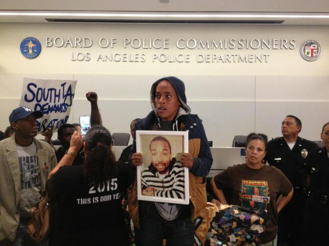 A woman holds a photo of Ezell Ford during a police commissioner meeting on his shooting death on Tuesday, June 5, 2015.