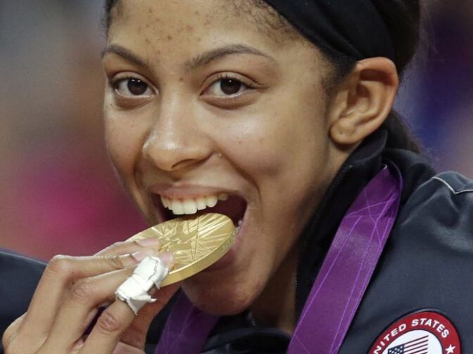 United States' Candace Parker bites her gold medal after beating France during the women's gold medal basketball game at the 2012 Summer Olympics, Saturday, Aug. 11, 2012, in London. 
