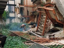 A construction worker using a chain on January 24, 1994, starts to cut up some of the destroyed walls in the courtyard of Northridge Meadow, the apartment complex that collapsed during the Northridge earthquake. Sixteen people were killed when the building collapsed during the quake. Councilman Tom LaBonge is now proposing an inventory of so-called "soft-story" buildings — those where the top stories could collapse onto the lower floor during a major temblor.