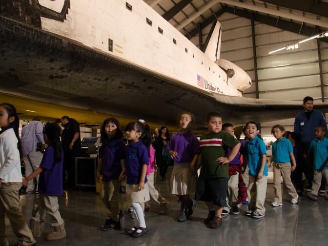 Children laughed and played as they walked past Space Shuttle Endeavour during the grand opening of the exhibition at the California Science Center in Los Angeles, Calif., October 30, 2012.