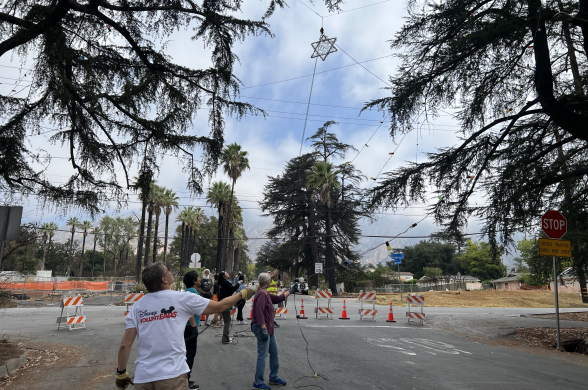 Volunteers with the Christmas Tree Lane Association hang up a giant star and other lights on the first day of work ahead of the holiday season.