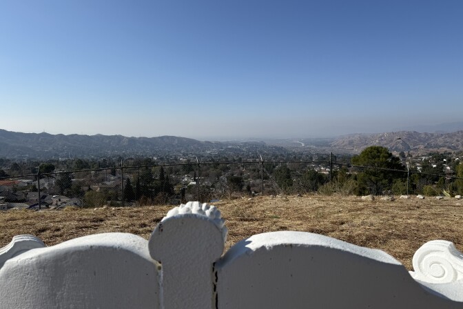 A panoramic view from the Verdugo Hills Cemetery in Sunland-Tujunga. Trees, house and rolling hills are in the background. 