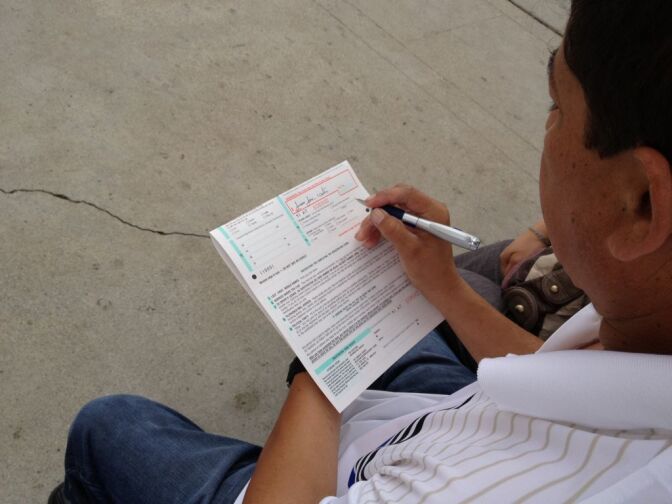 An eligible voter fills out a form outside  St. Joseph’s Catholic church in Hawthorne, where parishioners set up a registration table Sunday.