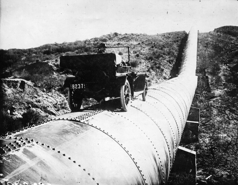 February 17, 1914: Mr. Bert Dingley drives a car along a section of the immense aqueduct of Los Angeles, California.