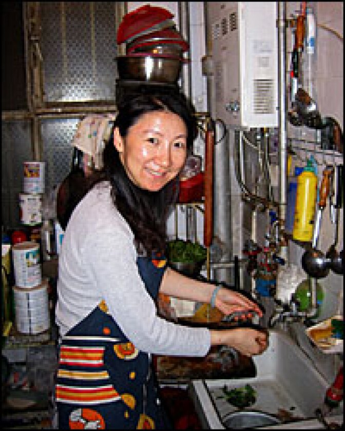 Editor Li Shujuan shells shrimp for dinner. She says her family must work harder to maintain its standard of living as food prices soar.