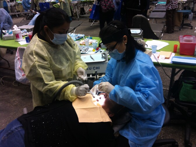 A patient receives free dental care at Care Harbor/LA, a massive mobile clinic that opened Thursday, Oct. 31, 2013, and continues for four days. The free clinic was set up to help individuals and families who are uninsured, underinsured or otherwise at-risk and in need of care.