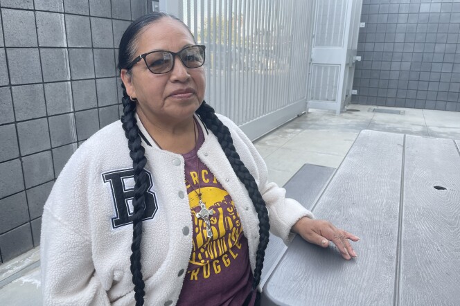 A woman with braids and glasses poses for photograph. 