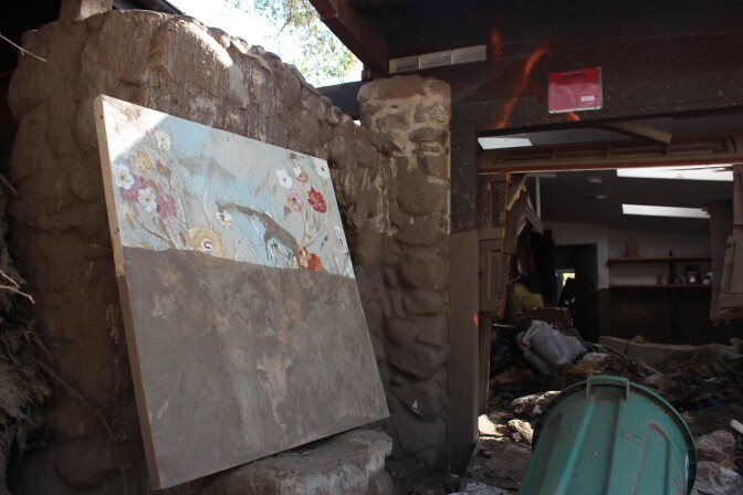 A painting half-covered in mud from the debris flows two months earlier stands outside a "red-tagged" home in Montecito on Thurs., March 8, 2018.