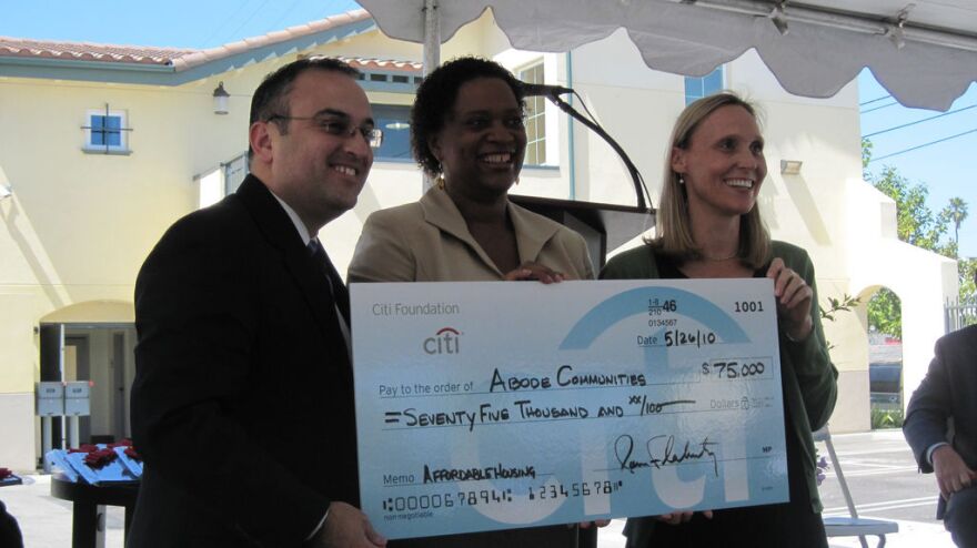 From left to right, Fernando Villa, Robin Hughes and Alice Carr stand with a check for Adobe Communities for $75,000.