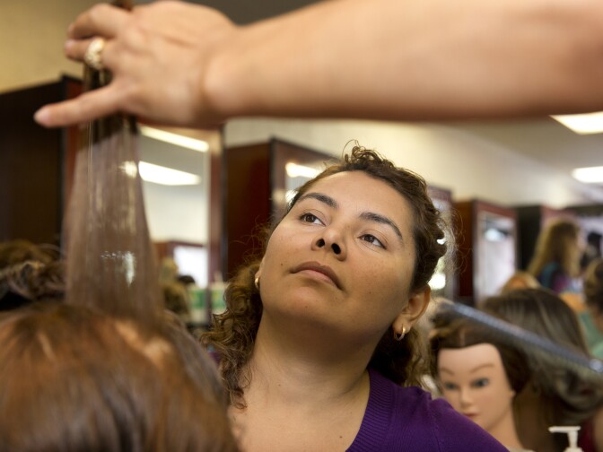 Apprentice Mirian Palacios learns hair cutting technique at Cosmetica in Downey on Oct. 5, 2015.