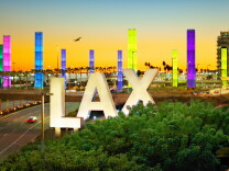 An image of the LAX Airport entrance lit up with Pride colors.