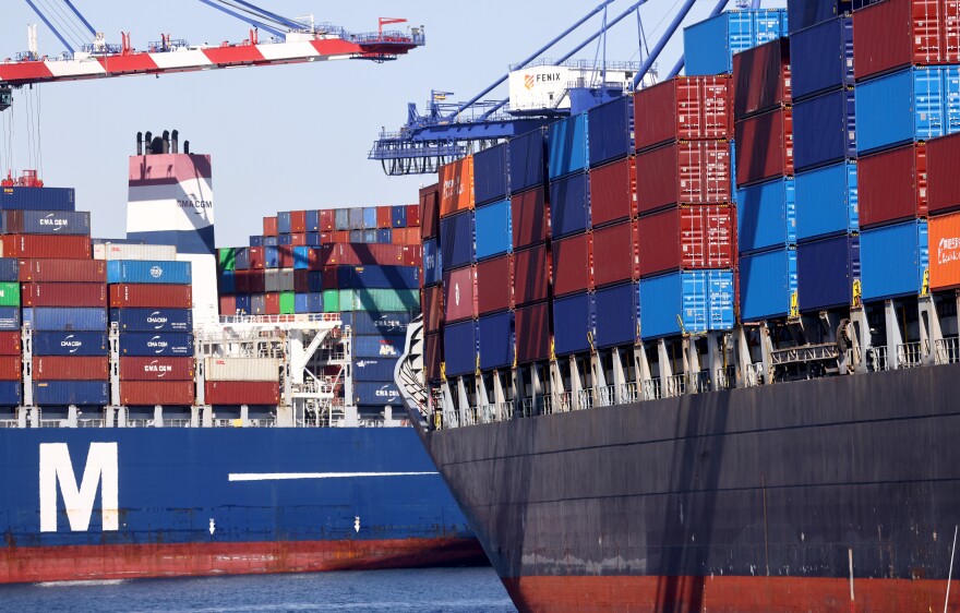 Colorful containers are stacked as high as nine in a a row on two large container ships.