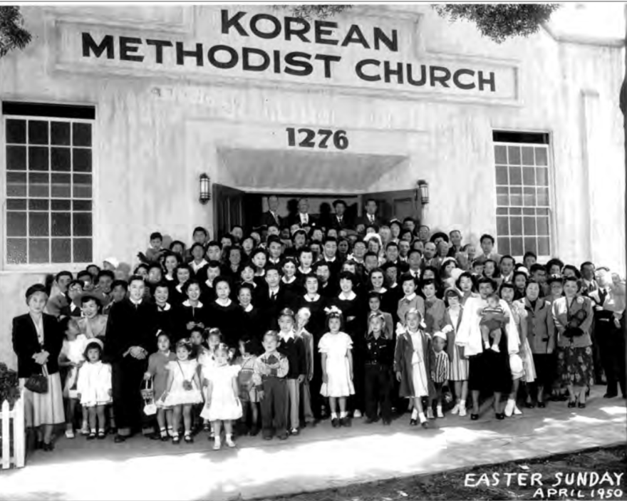 Dozens of congregants in suits and Sunday dress clothes stand in from of a building with the block letters "KOREAN METHODIST CHURCH" and the street number 1276.