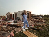 Nathan Ulepich searches outside the back of his house destroyed after a powerful tornado ripped through the area on May 20, 2013 in Moore, Oklahoma. The tornado, reported to be at least EF4 strength and two miles wide, touched down in the Oklahoma City area on Monday killing at least 51 people. 
