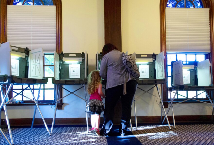 A little girl watches her mother vote on June 5, 2012 at City Hall in Hudson, Wisconsin, for current Governor Scott Walker or challenger Milwaukee Mayor Tom Barrett.