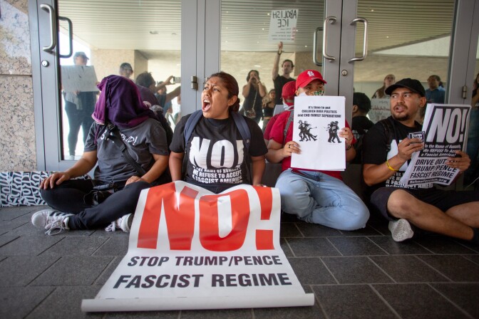 Michelle Xai, center, leads a chant as her and other protesters block the doors to the Metropolitan Detention Center in protest to the Trump administrations family separations related to the zero-tolerance policy along the border, in Los Angeles, California, June 21, 2018.