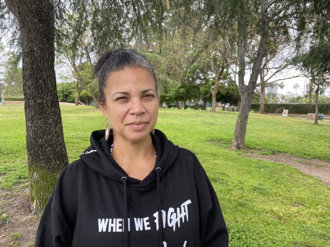 Black Lives Leader Melina Abdullah stands underneath a tree at Pan Pacific Park, one year after her group led a massive protest over the murder of George Floyd.