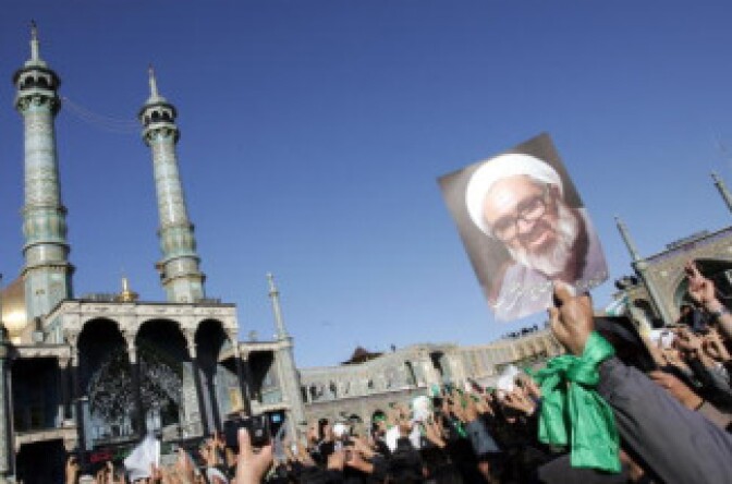 Iranians hold portraits of Iranian cleric Grand Ayatollah Hossein Ali Montazeri during his funeral procession in the holy city of Qom on December 21, 2009. 