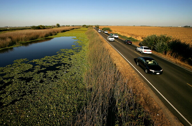 File: Water is held back from a lower-elevation farm (R) by a section of Highway 4 that serves as a levee road in the Sacramento-San Joaquin River Delta, west of Stockton.