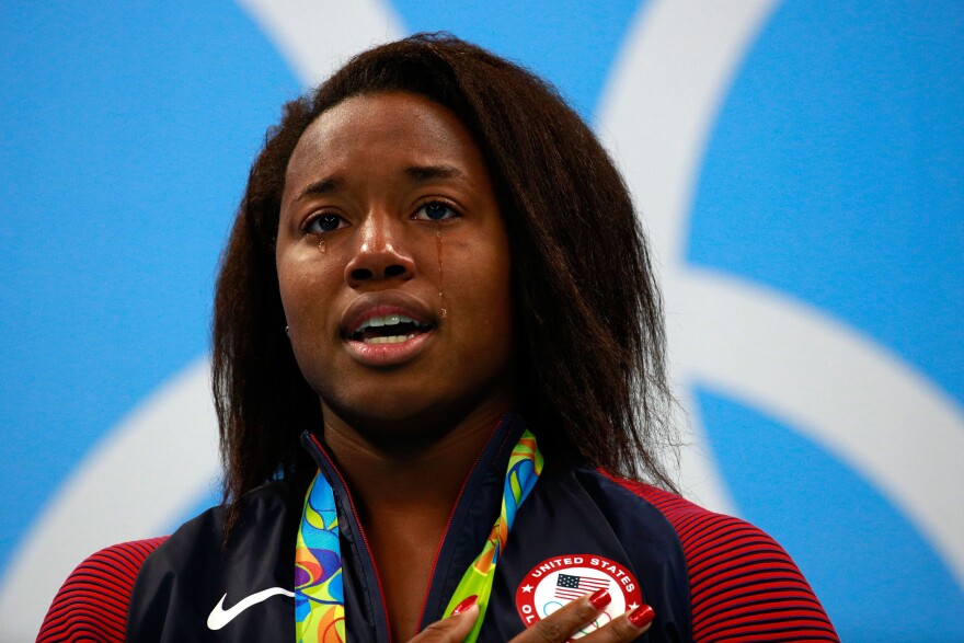 RIO DE JANEIRO, BRAZIL - AUGUST 11:  Gold medalist Simone Manuel of the United States celebrates on the podium during the medal ceremony for the Women's 100m Freestyle Final on Day 6 of the Rio 2016 Olympic Games at the Olympic Aquatics Stadium on August 11, 2016 in Rio de Janeiro, Brazil.  (Photo by Adam Pretty/Getty Images)