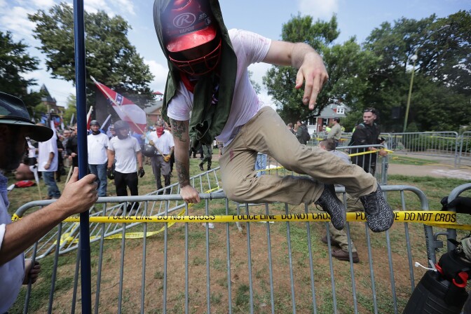 CHARLOTTESVILLE, VA - AUGUST 12:  White nationalists, neo-Nazis and members of the "alt-right" leap over barricades inside Lee Park during the "Unite the Right" rally August 12, 2017 in Charlottesville, Virginia. After clashes with anti-fascist protesters and police the rally was declared an unlawful gathering and people were forced out of Lee Park, where a statue of Confederate General Robert E. Lee is slated to be removed.  (Photo by Chip Somodevilla/Getty Images)