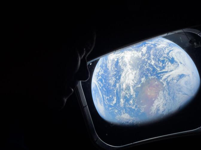 A view of the Earth is seen from the window of a spacecraft.