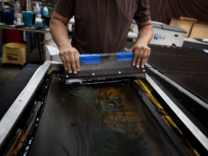 Enrique Tio silk screens Karen Kane t-shirts at the Vernon based warehouse. Tio is currently working 10 hour days to meet the high demand.