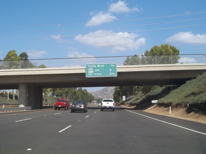 Photo shows northbound California State Route 133 and sign stating distances to Irvine Boulevard, Route 241 Toll and Toll Plaza.