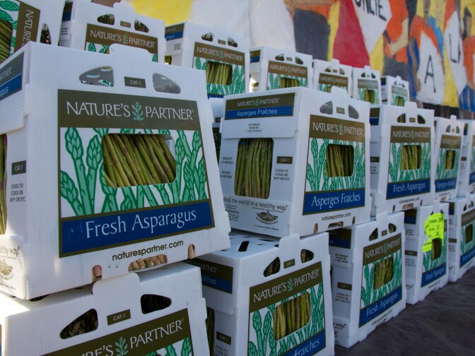 The collective distributed food, like these boxes of fresh asparagus, to needy locals.