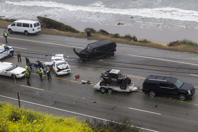 The Los Angeles Coroner is assisted by law enforcement officers to remove the body of a victim of a car crash where one person was killed and at least seven other people were injured, in a chain reaction, head-on crash in Malibu Calif. on Saturday Feb. 7, 2015. The SUV with a trailer is belong to Reality-TV star Bruce Jenner.