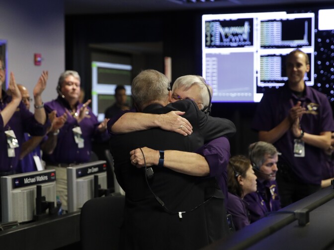 Project manager Earl Maize, center, left, and flight director Julie Webster hug in mission control at NASA's Jet Propulsion Laboratory, Friday, Sept. 15, 2017, in Pasadena, Calif., after confirmation of Cassini's demise. Cassini disintegrated in the skies above Saturn early Friday, following a remarkable journey of 20 years. (AP Photo/Jae C. Hong, Pool)