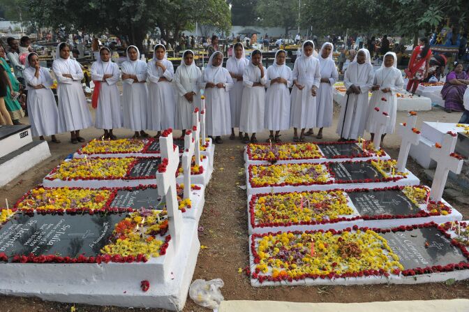 Indian Catholic nuns offer prayers at the graves of deceased sisters at a cemetery during All Souls Day in Hyderabad on November 2, 2016.