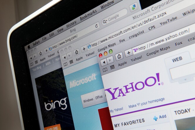A close-up image of the corner of a laptop screen with several browsers open, each featuring a different website: Yahoo, Microsoft and Bing. 