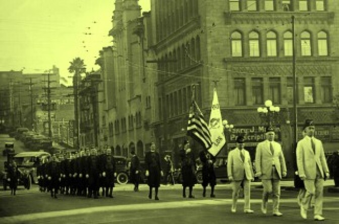 Undated photo of a Shriners parade walking past 5th and Olive Streets in Downtown LA. On the right corner is the Philharmonic Auditorium Building, which shared space with Temple Baptist Church. 
