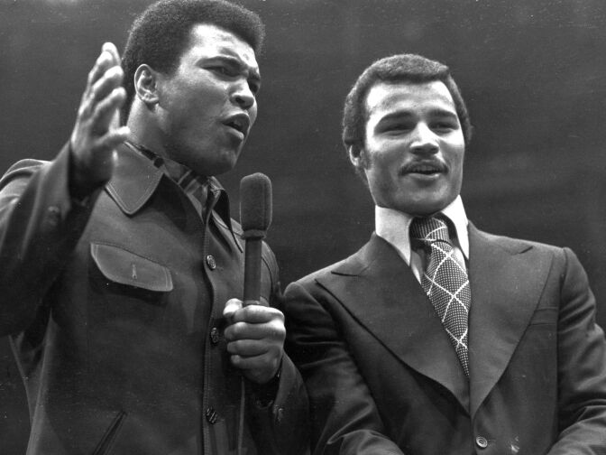 1974:  American heavyweight boxer Muhammad Ali with British champion John Conteh.