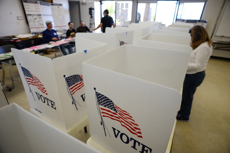 People vote at a polling place at the lifeguard station in Manhattan Beach, California, November 4, 2014.
