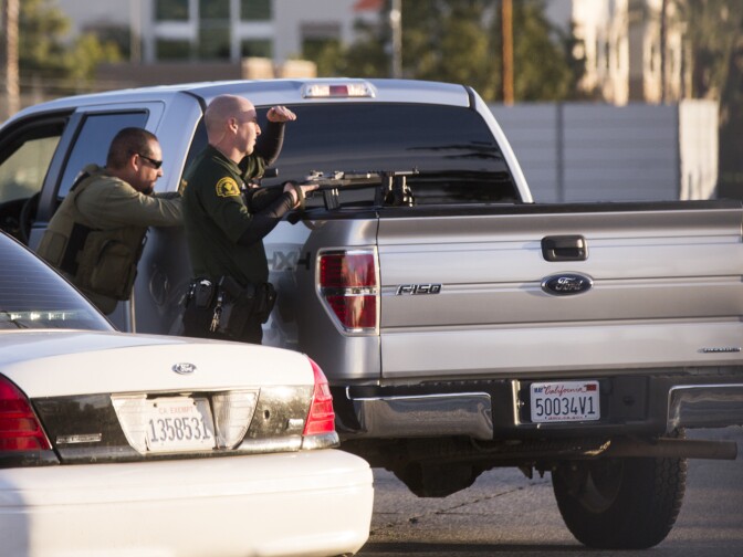 San Bernardino Sounty Sheriff's deputies draw their guns on South Mountain View Avenue near San Bernardino Avenue in Redlands, Calif. on Wednesday, Dec. 2, 2015 during an active shooter situation following a mass shooting at the Inland Regional Center.